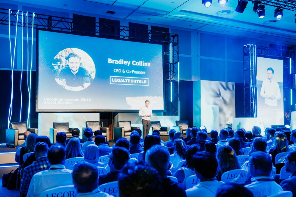 A speaker addressing a full room of attendees at the LegalTechTalk