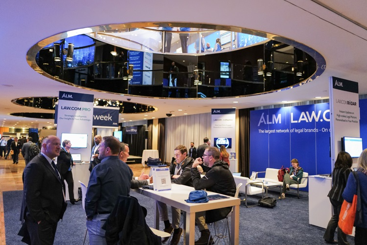 Des professionnels du droit réseautant dans le hall d’exposition de Legalweek